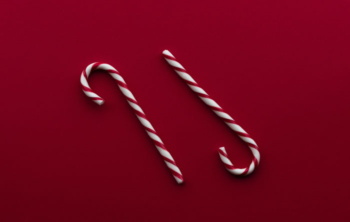 Two candy canes on the red background 