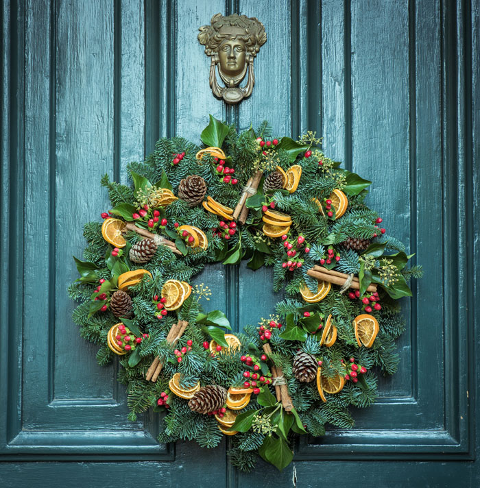 Green door wreath on the wooden door 