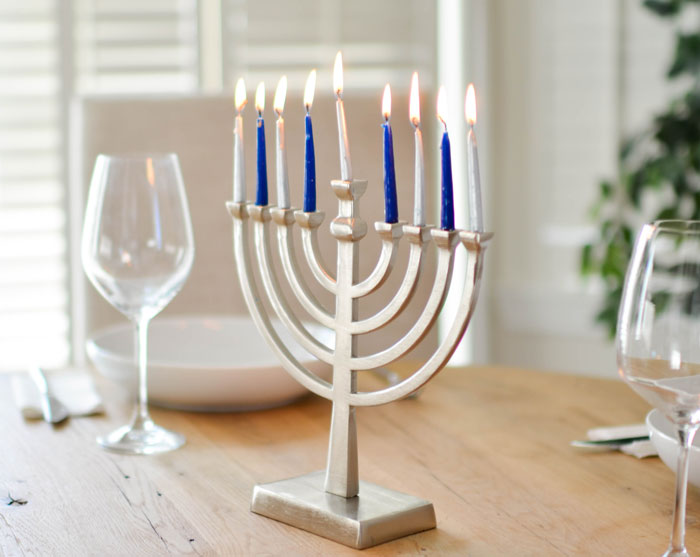 Brass-colored candel holder on the brown table 