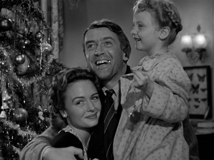 George and Mary with their daughter smiling near Christmas tree