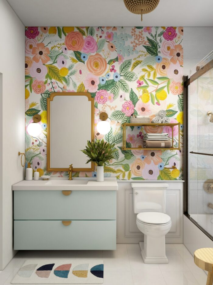 Bathroom featuring trendy flower wallpaper, a sink with blue cabinets, and a white toilet in a bright space. Bathroom featuring trendy flower wallpaper, a sink with blue cabinets, and a white toilet in a bright space.