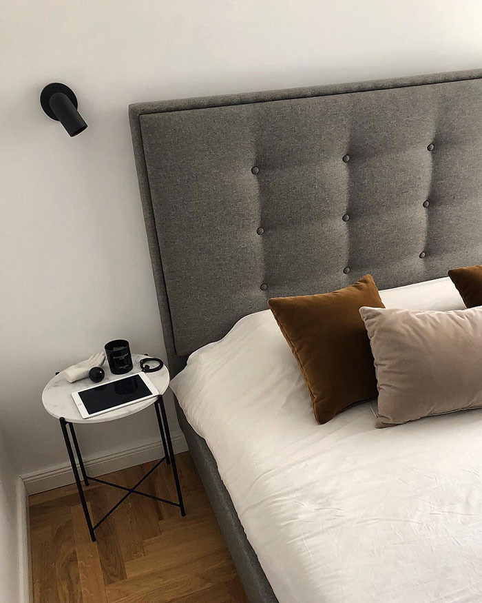 Colorful pillows arranged on a gray upholstered bed with a bedside table, showcasing stylish home decor ideas. Colorful pillows arranged on a gray upholstered bed with a bedside table, showcasing stylish home decor ideas.