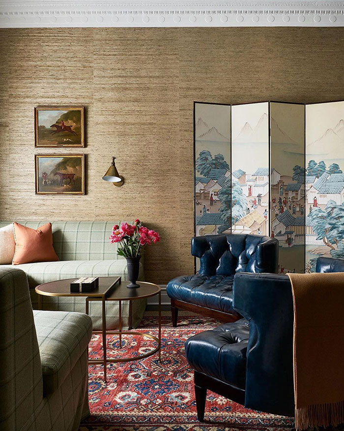 Spacious living room with vintage furniture, leather chairs, patterned rug, and floral accents showcasing home decor ideas. Spacious living room with vintage furniture, leather chairs, patterned rug, and floral accents showcasing home decor ideas.