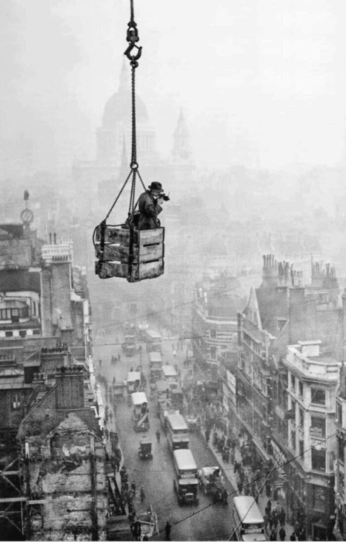 Fotógrafo colgado de una grúa haciendo fotos de las calles de Londres, 1929