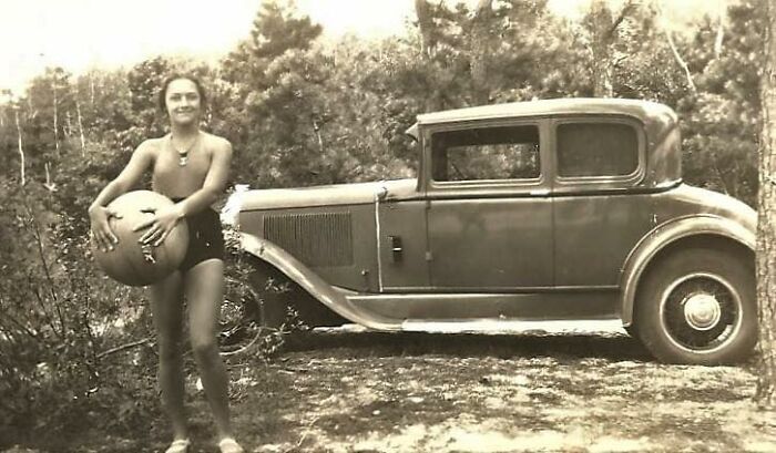 A Fit Girl Posing With Her Old Car In 1934