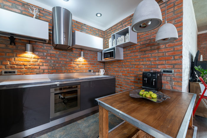 red rustic brick kitchen with wooden kitchen island in the middle