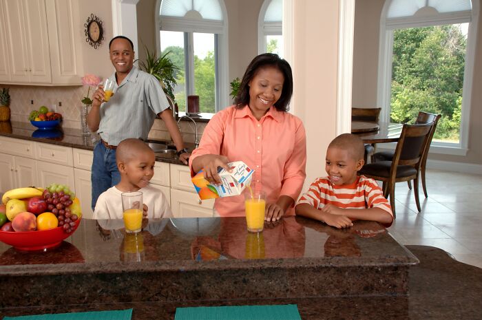 Parents with children smiling and drinking juice
