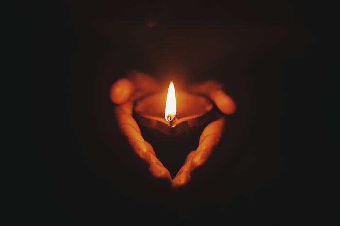 Person holding candle in the dark