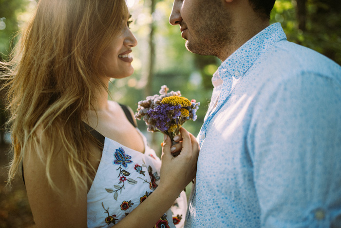 Man and woman looks at each other while holding flowers