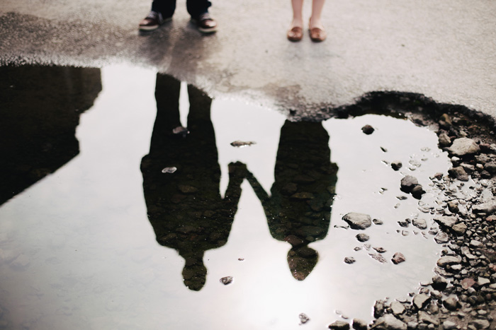 Reflection of a couple on a rain puddle