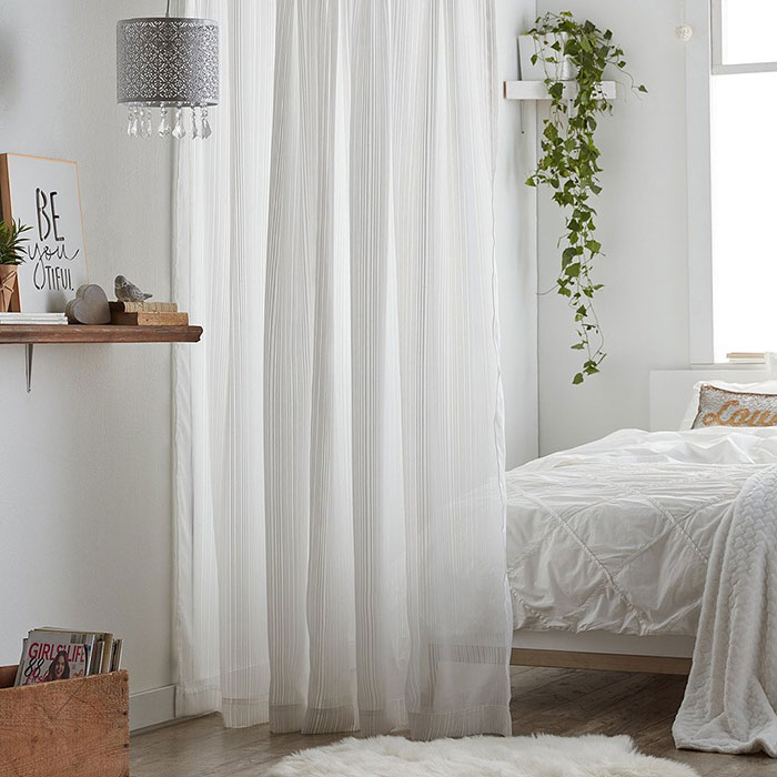 White bright bedroom with room divider as a curtain 