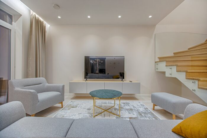 a minimalist room with a gray sofa set facing a TV