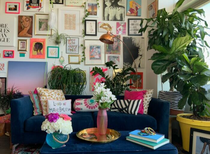 a maximalist living room with a blue couch and vases with flowers a maximalist living room with a blue couch and vases with flowers