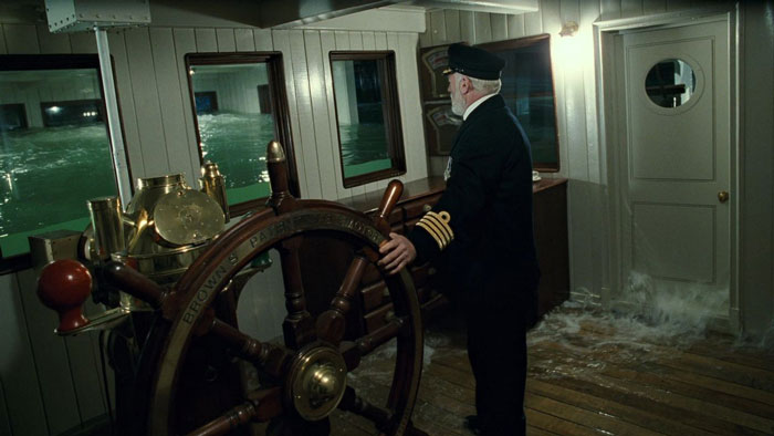 Captain Edward John Smith standing next to ship's steering wheel when the Titanic sinks in the 'Titanic' (1997) movie