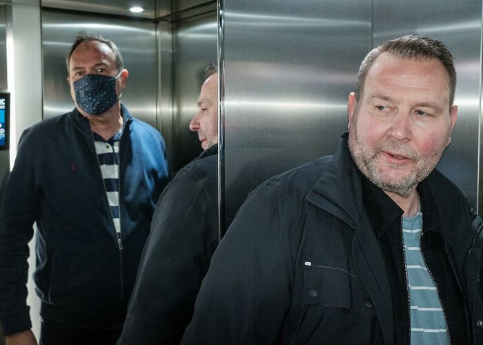 A Photograph Of People In An Elevator