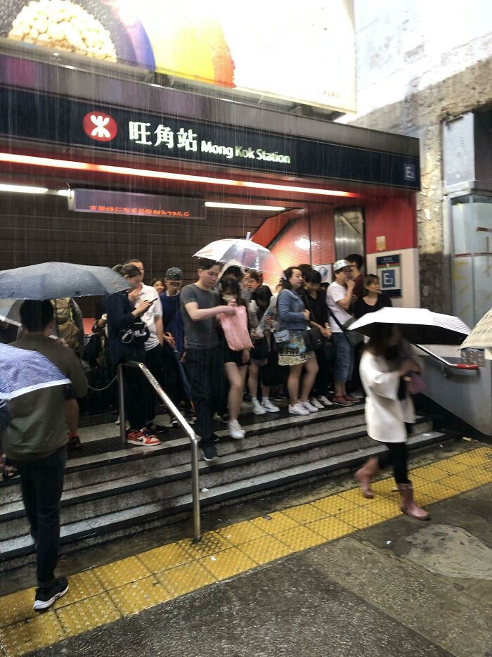 Umbrella-Less People Blocking A Subway Exit For Shelter During An Unexpected Downpour In Hong Kong