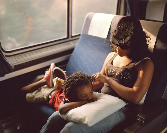 Madre arreglando el pelo de su hijo en el tren