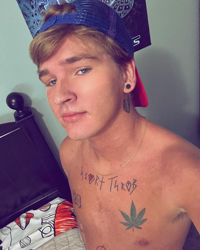 TikToker Ethan with tattoos, including a heart, posing shirtless against a bedroom backdrop. TikToker Ethan with tattoos, including a heart, posing shirtless against a bedroom backdrop.