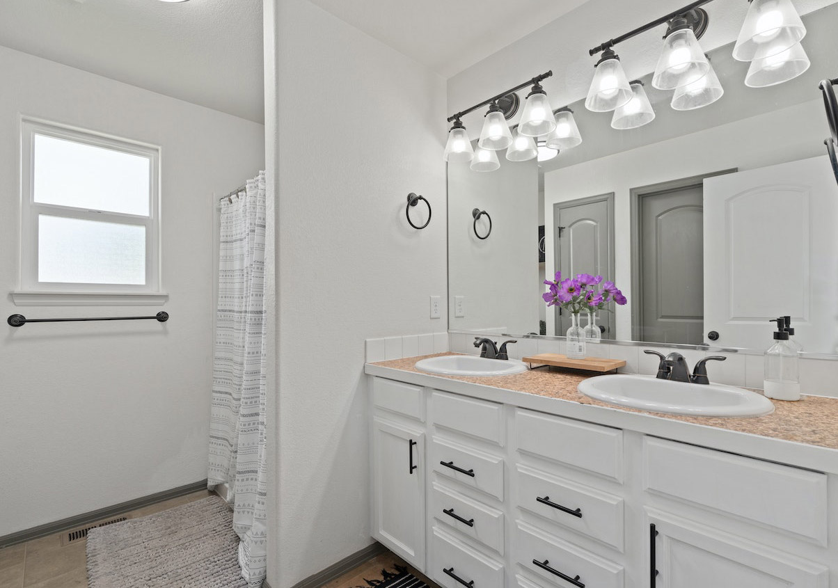 White bathroom with sconces over the mirror