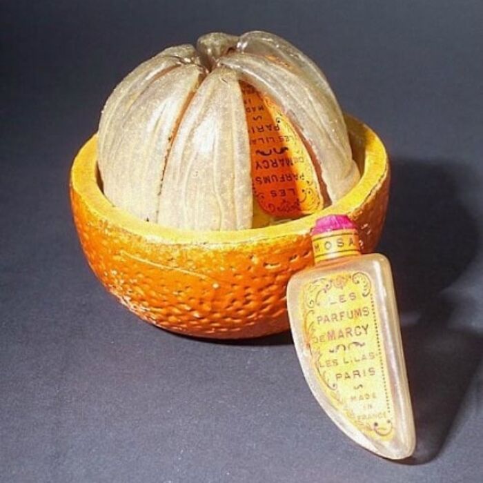 Perfume Bottle Consisting Of Eight Glass Bottles As Orange Segments, Set In Painted Ceramic Holder. (Ca. 1925)