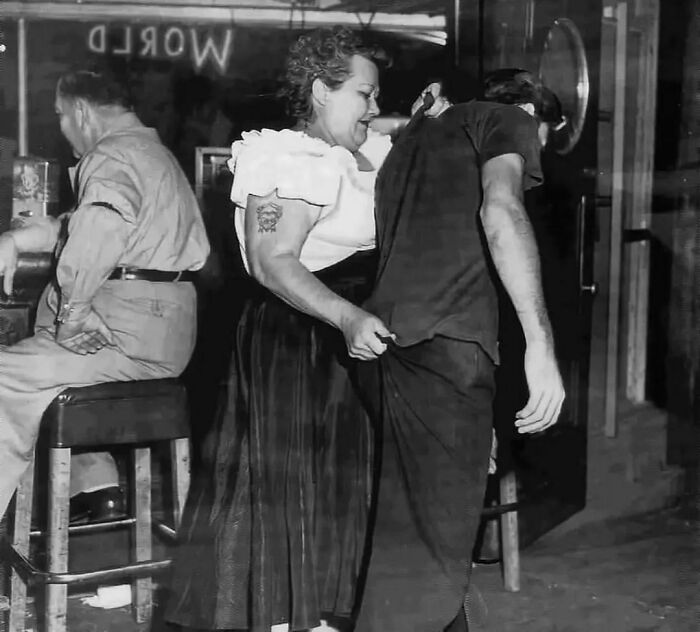 1953: Cairo Mary,portera en el club Shanghai Reds, escoltando a un cliente hasta la puerta