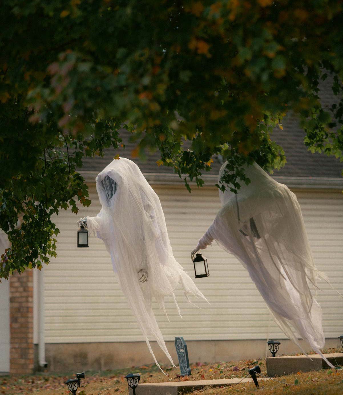 Two DIY ghosts hanging on a tree