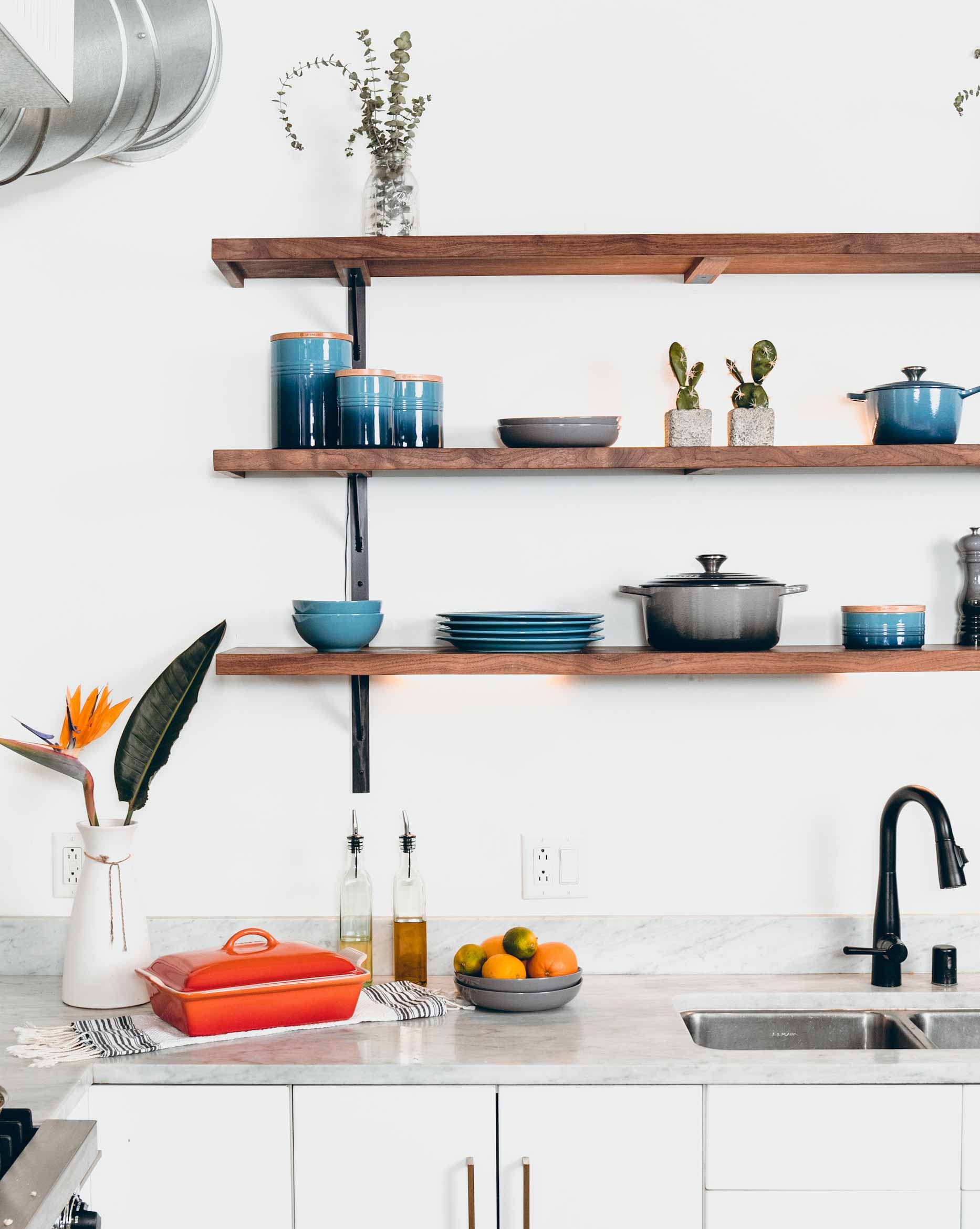 White kitchen with wooden shelves, dishes and plants
