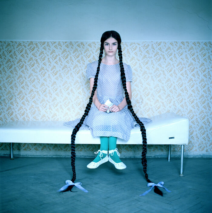 An image of a sitting girl with long braids