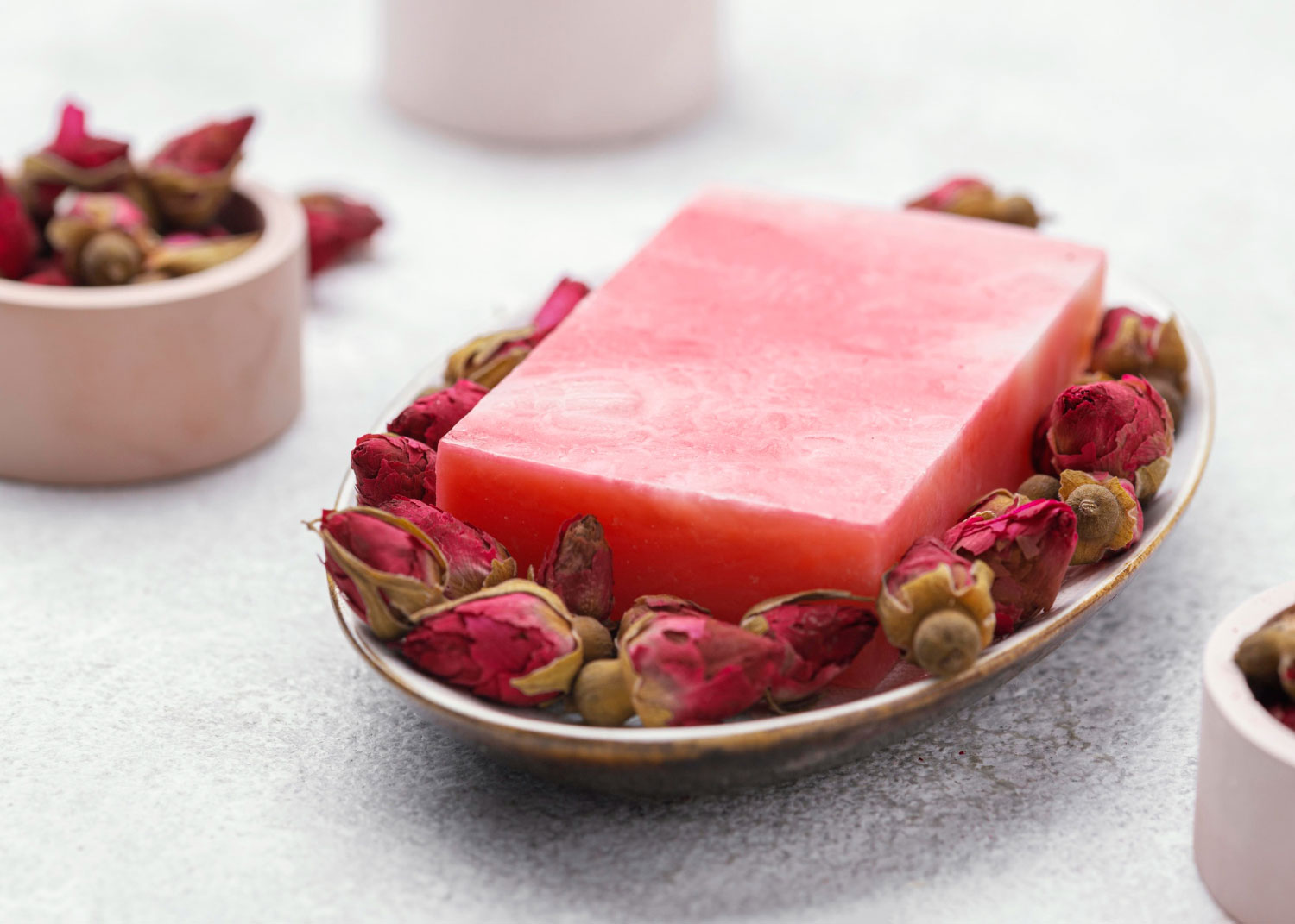 Pink soap in a tray with dried roses
