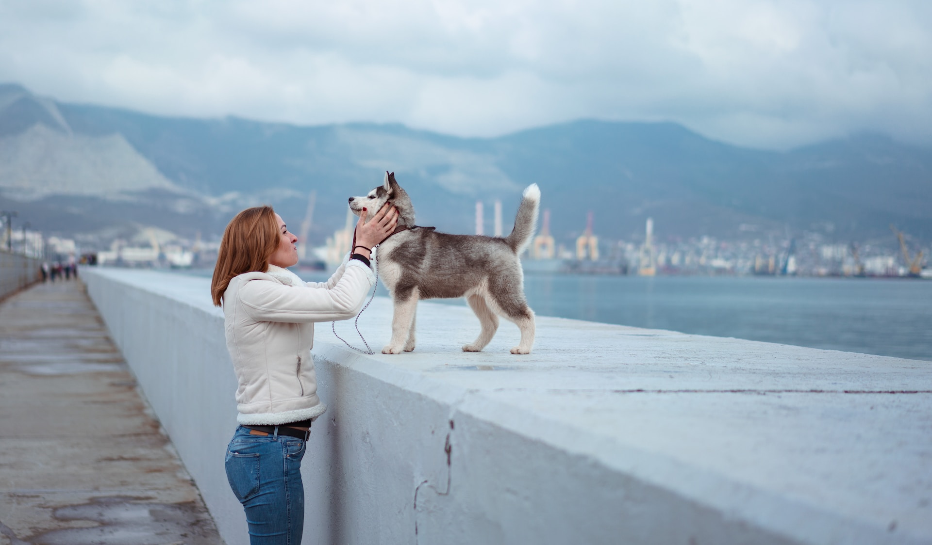 a woman petting a Siberian Husky