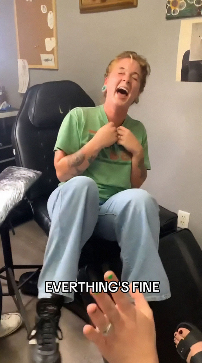 Person in a green shirt laughing on a tattoo chair, experiencing a humorous tattoo blunder, captured for TikTok. Person in a green shirt laughing on a tattoo chair, experiencing a humorous tattoo blunder, captured for TikTok.