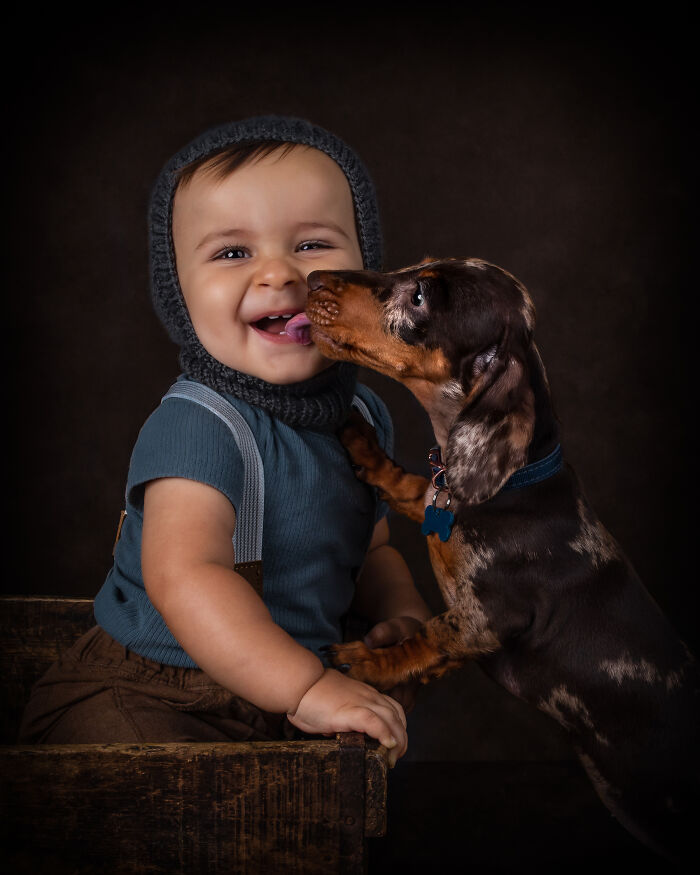 Little child getting a kiss from the dog