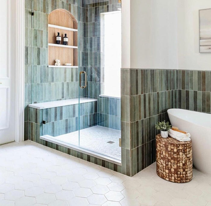 bathroom with green vertical tiles and hexagon floor tiles