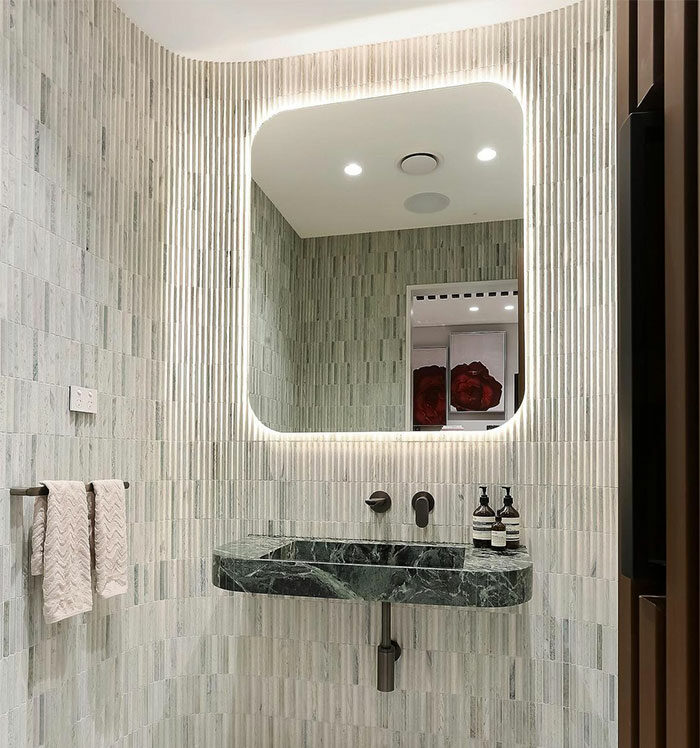 bathroom with vertical small tiles and sink