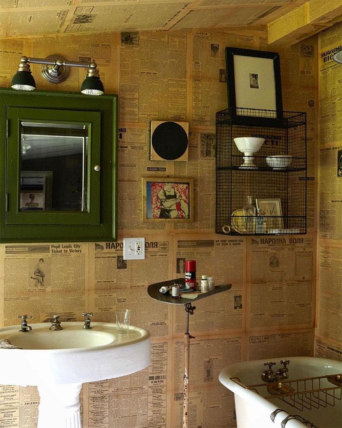 funny bathroom with old newspaper wallpapers and sink
