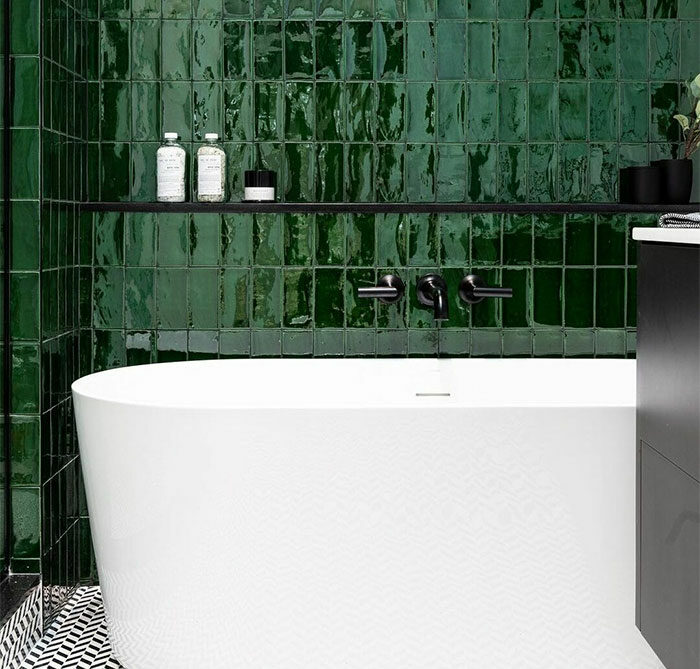 bathroom with green glass tiles on the wall