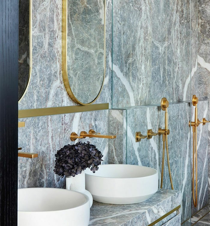 bathroom with granite tiles on walls and white sinks