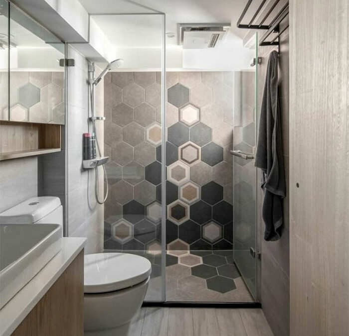 bathroom with hexagon tiles on wall, toilet and sink
