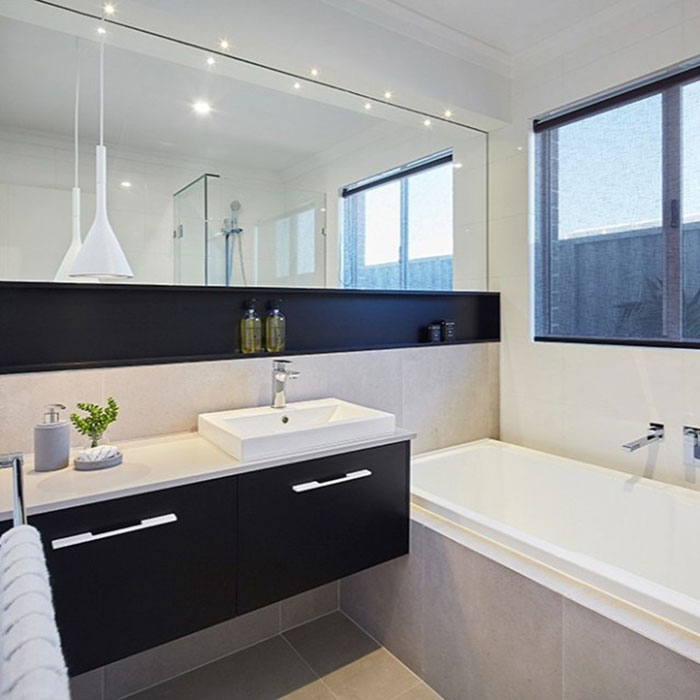 modern black and white bathroom with huge mirror and bathtub