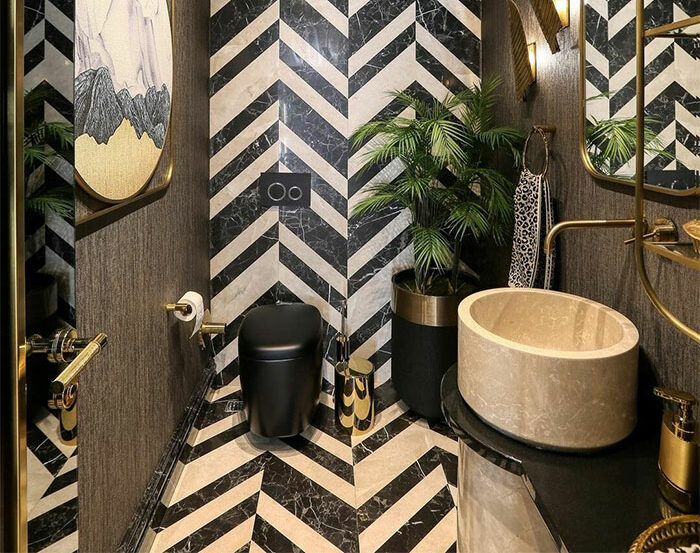 bathroom with black white chevron tiles with sink and toilet