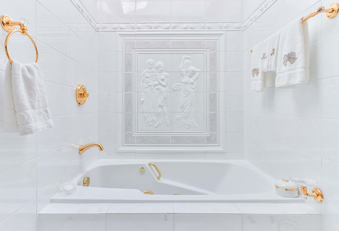 all-white ceramic bathroom with golden accessories