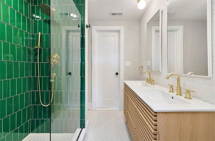 bathroom with green shower tiles and sink