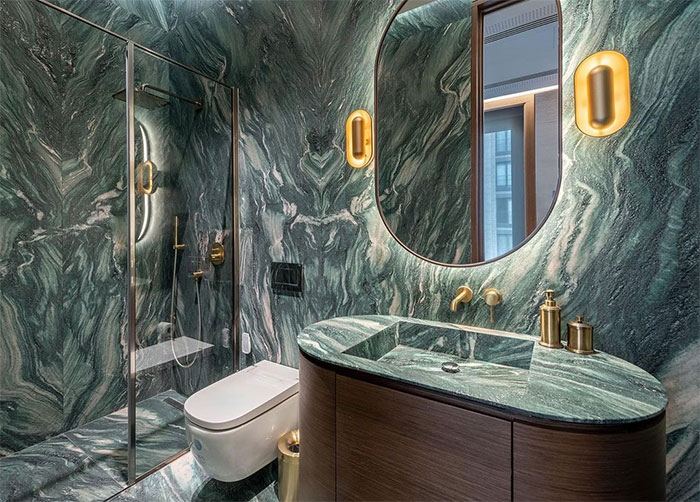 bathroom with green marble tiles sink and toilet