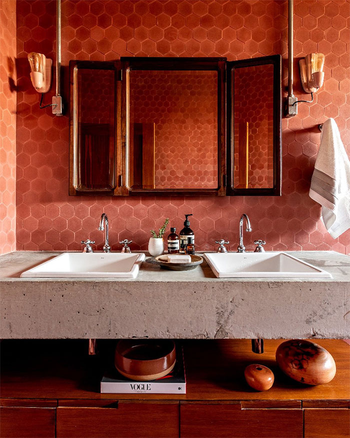 bathroom with red hexagon tiles on walls and white sinks