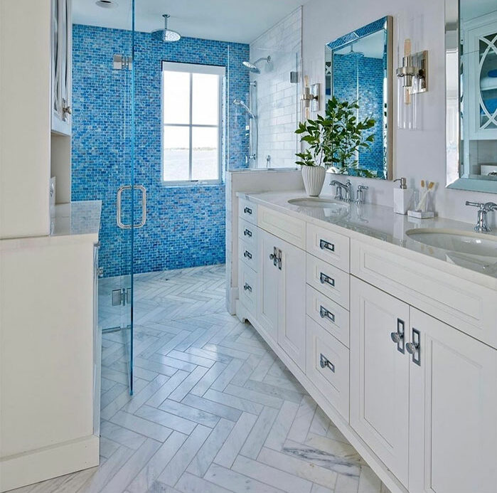 blue bathroom with mosaic shower tiles white chevron floor tiles and white sink