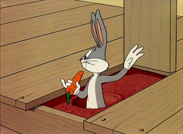 Bugs Bunny in a hole eating a carrot while holding wooden plank 
