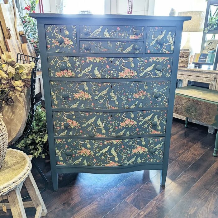 A blue chalk-painted dresser with flowers and bird designs