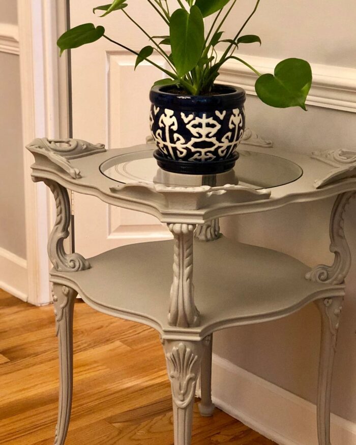 Gray chalk-painted end table with a flower vase
