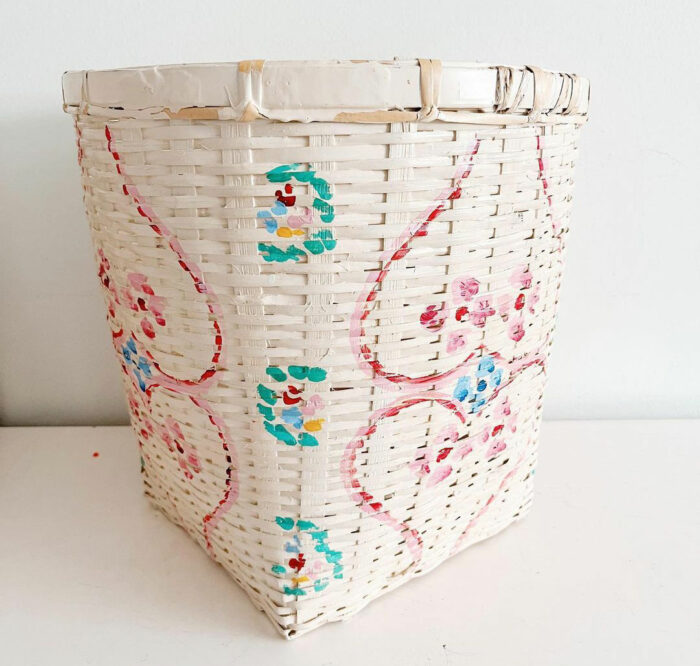 A white chalk-painted basket with flower decorations