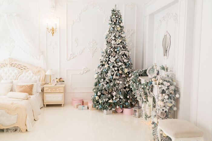Christmas tree with ornaments in white bedroom